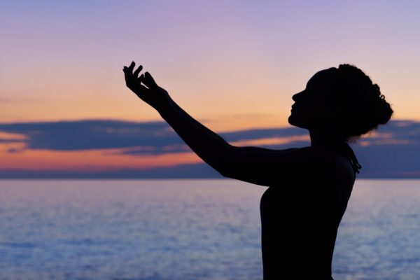 woman with hands raised to the sky