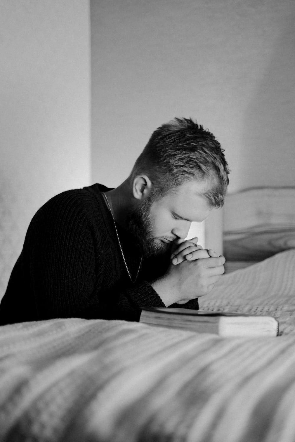 man praying by his bedside