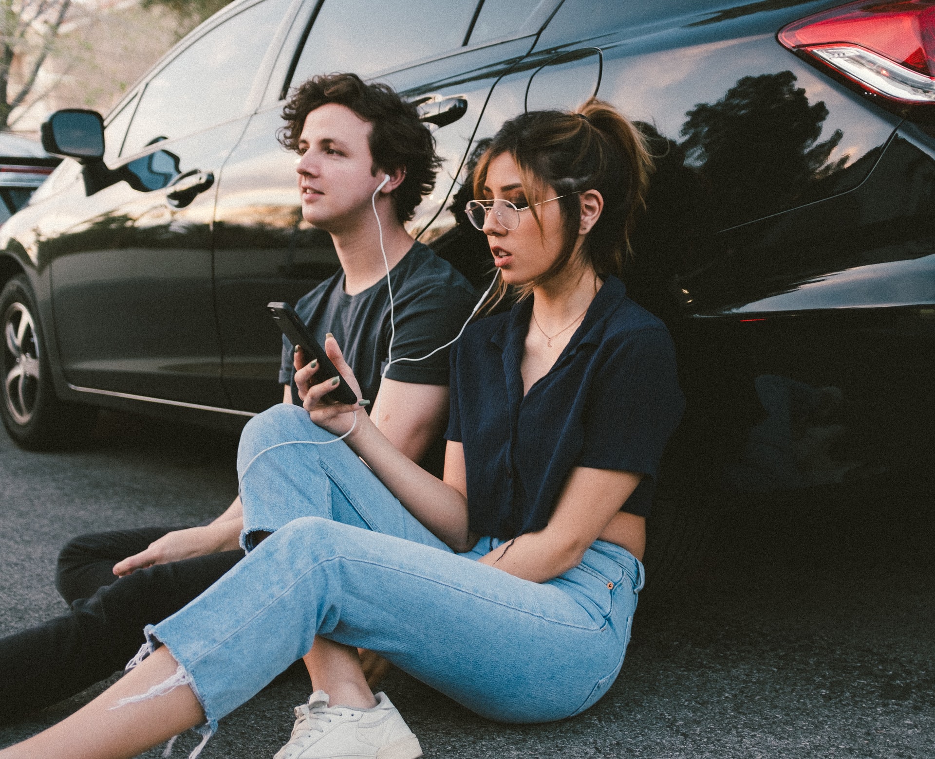 man and woman listening to music together on earphones