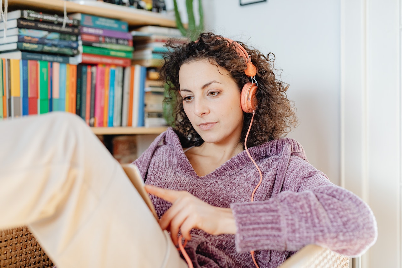 Woman listening to music while reading